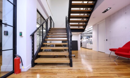 Modern office with staircase and wooden floors.