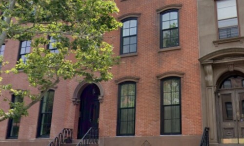 Historic brick townhouse with ornate staircase.