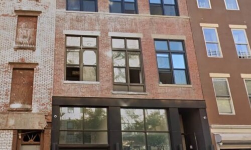 Three-story brick building with large windows.