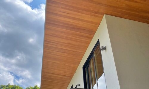 Modern house with wooden roof overhang.