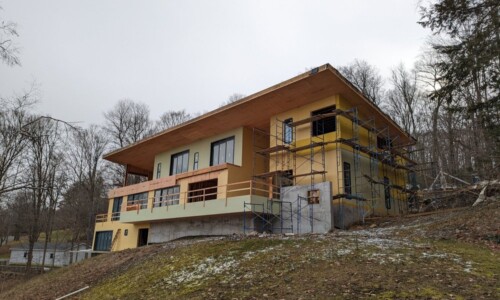 House under construction surrounded by trees.