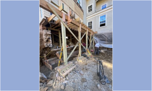 House foundation under construction with wooden supports.