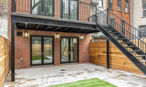 Brick patio with stairs and balcony.