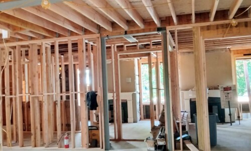 House under construction with exposed wooden framing.
