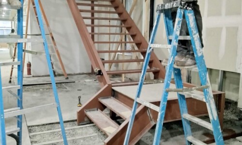 Construction site with metal stairs and ladders.