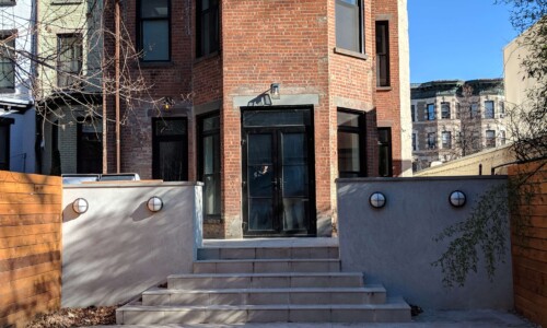 Red brick house with concrete steps outside.