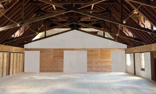 Dark wooden trusses and suspended work lights