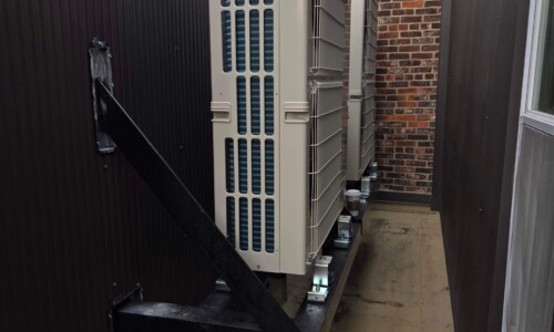 Outdoor air conditioning unit on wall bracket.