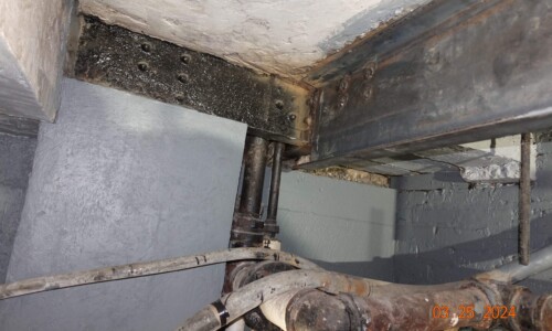 Basement corner with metal beams and pipes.