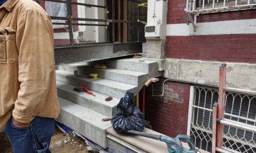 Building entrance with concrete steps under construction.