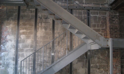 Metal staircase against a brick wall.