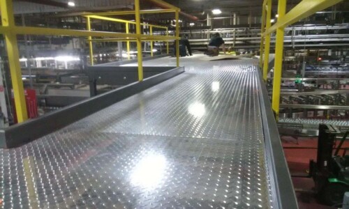 Industrial metal walkway with yellow railings.